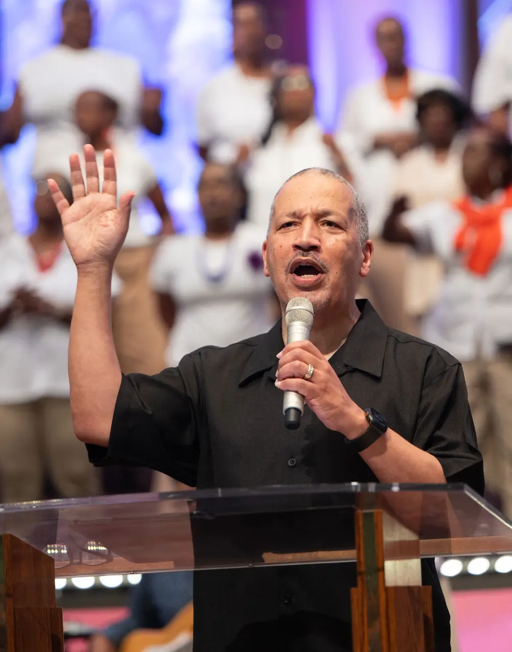 Dr. Lance D. Watson preaching with hand raised